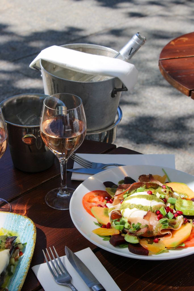 Table en terrasse au Petit Paris avec verre de vin et salade Méli-Mélo
